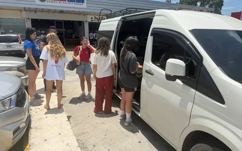 Travelers boarding our shared van with their backpacks